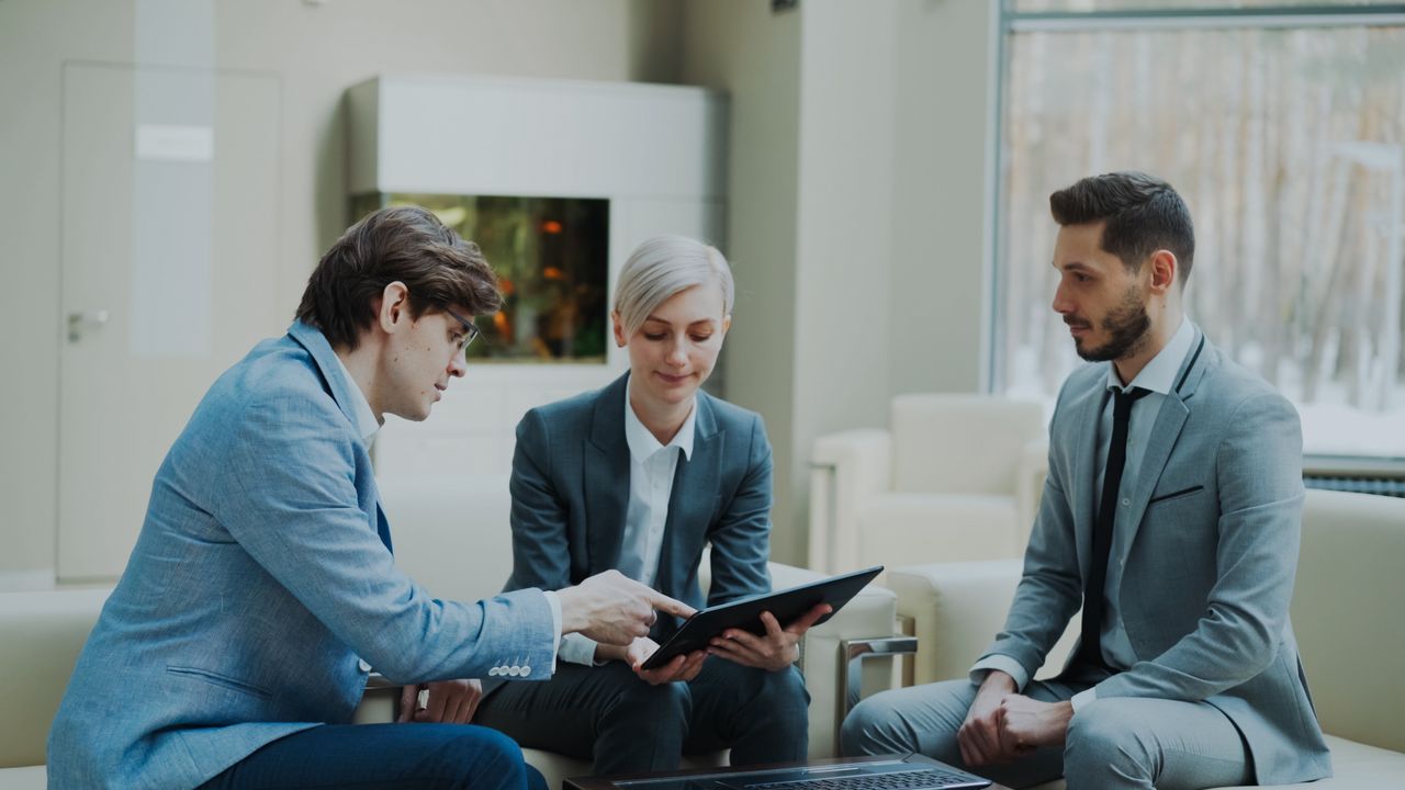 Crafting Captivating Headlines: Your awesome post title goes here Three professionals engaging in a business meeting in a modern office setting.